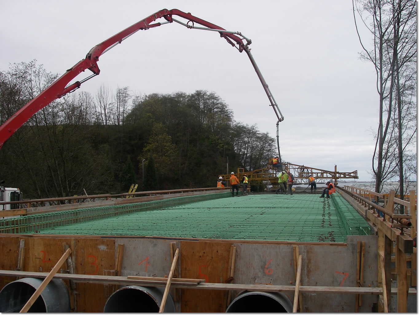 Workers constructing and pouring the bridge deck.